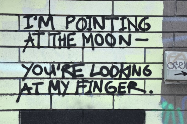 graffiti that says I'm pointing at the moon - You're looking at my finger