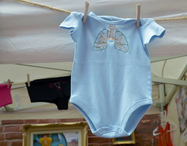 a light blue onesie with a diagram of a pair of lungs silkscreened on it.