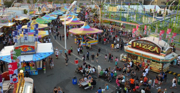 birds eye view of the midway.  multicoloured roofs over midway game stalls, lots of people walking around