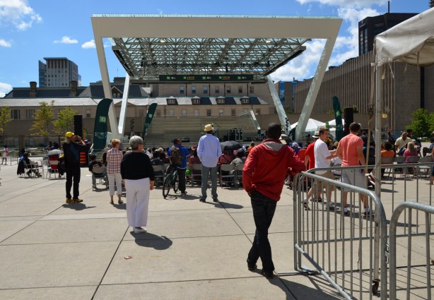 people watching a performance at Nathan Phillips Square on a sunny afternoon