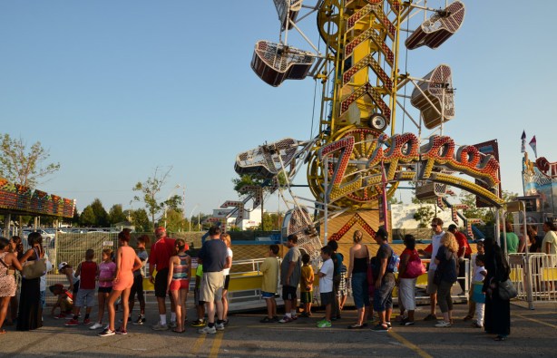 many people in a line up waiting to get on the Zipper ride