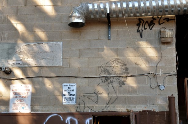 graffiti image of a naked woman who is wearing an Indian feather headdress