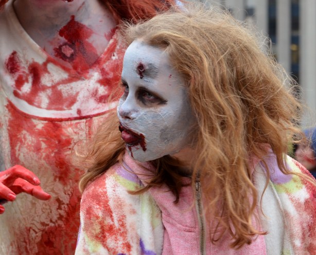 a girl with red frizzy hair who has white makeup on her face and a bloody mouth
