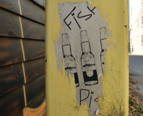A paper sticker showing three beer bottle shaped bottles with labels that say fish piss.