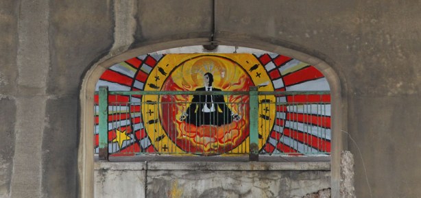 center part of the mural showing a man wearing a suit who is sitting in the lotus position