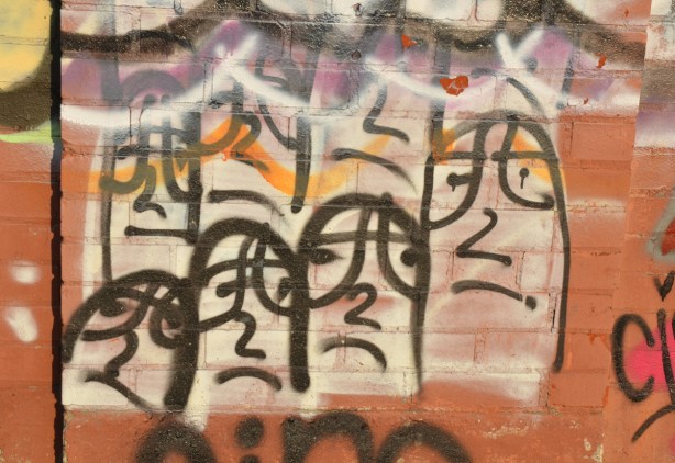graffiti of many white fingers in at least three rows of four. The fingers have eyes and their noses look like the number two.