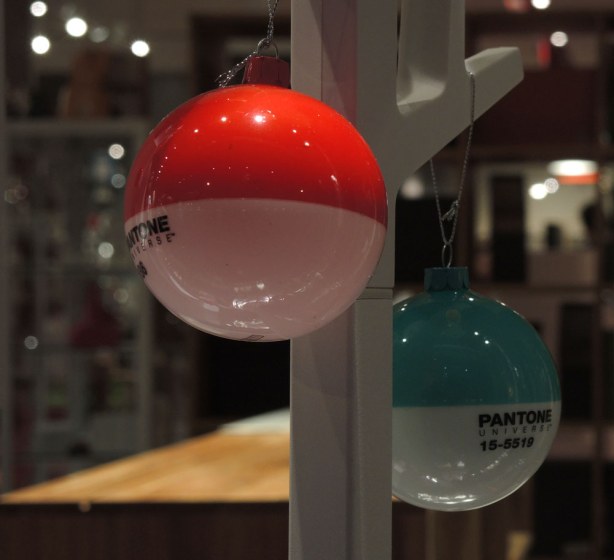 Two christmas tree balls.  Both are white on the bottom half and both are pantone colours on the top - one is red and the other is light blue, pantone universe color 15-5519 