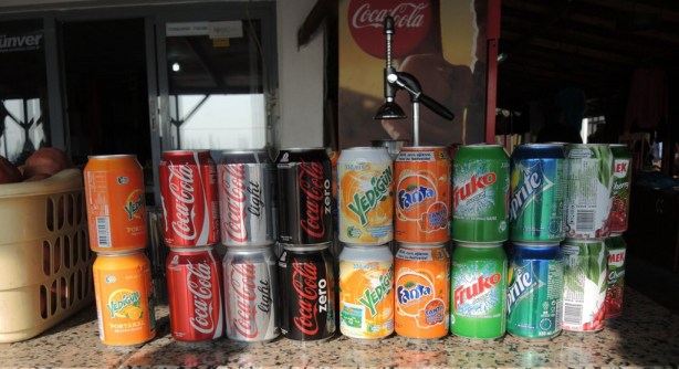 a line up of soft drink cans that are available for sale at a roadside fast food place in Turkey