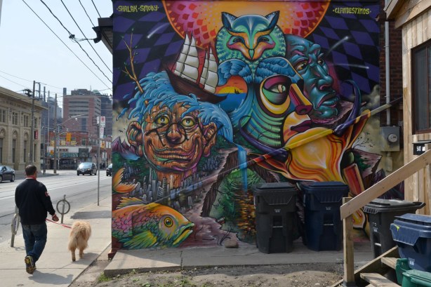 A large mural on the side of a brick house.  