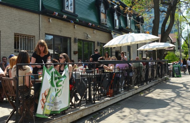 A number of people are having lunch on a patio.