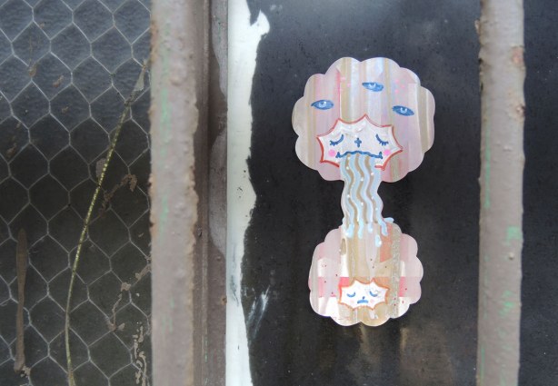 little people graffiti, sticker of two girls' heads.  They have puffy pink hair. 