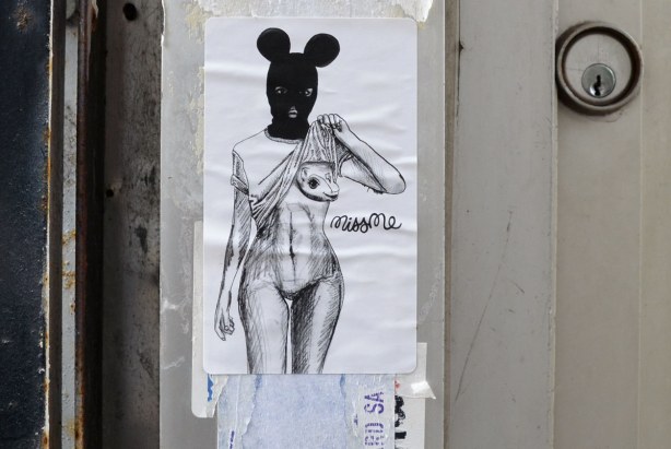 little people graffiti, black and white sticker with a picture of a semi naked woman's body with an animal's head and belly. 