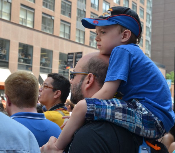 a boy is sitting on his father's shoulders