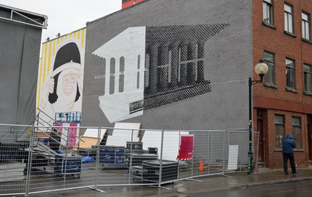 mural of a building that looks a bit like the parthenon in Athens, with many pillars, or columns.  The left side of the building is white and the right side is black.  