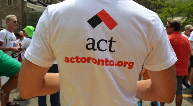 The back of a man's Tshirt with the logo for act along with their website 