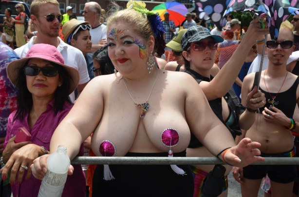 A woman with very large and almost bare breasts.  Her face is decorated 