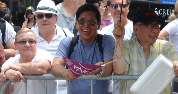 A group of men are standing behind barricades. 