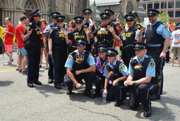 A group of policemen and policewomen pose for a group shot before the pride parade
