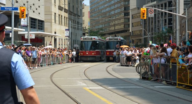 streetcars at the intersection of Yonge & College, all corners are packed with people