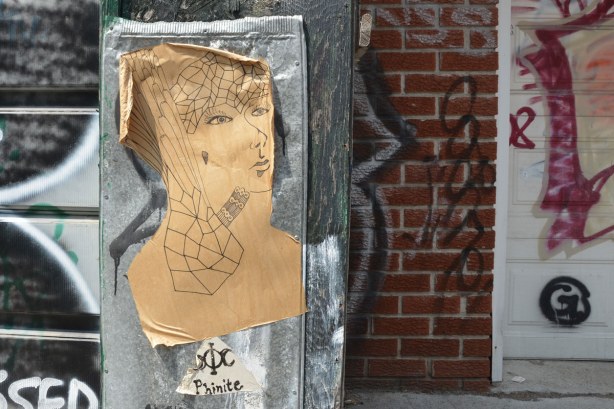 black ink on brown paper graffiti of a woman's head & shoulders 