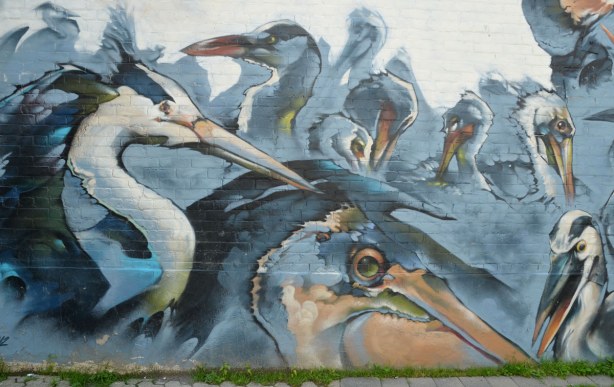 mural of many large birds in blues and greys, they all have long curved necks and large beaks