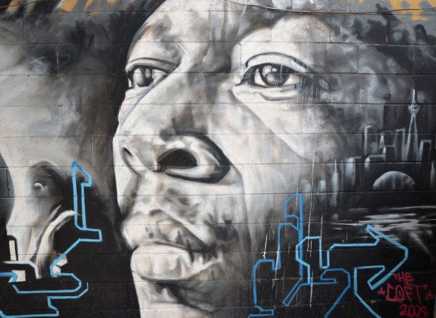 Large black & white & grey face of a famous black musician, probably jazz or blues but I'm not sure