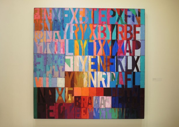 a very colourful painting that looks like a mosaic of diffferent coloured letters on different coloured squares and rectangles. 
