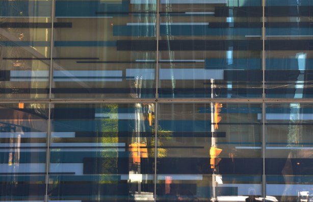 Reflections of streetlights in a window, lots of horizontal blue bars are in the windows too. 