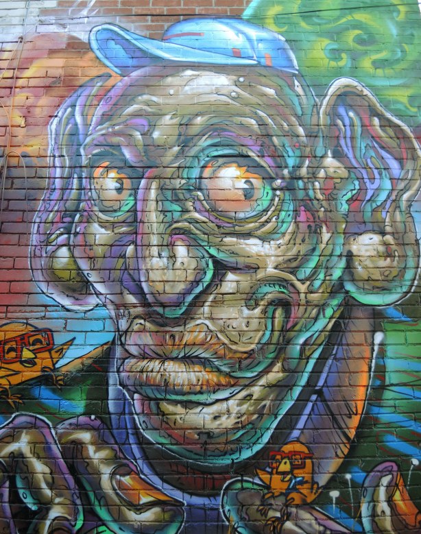 part of a large mural, a very large wrinkly man's face with large eyeballs and large ears
