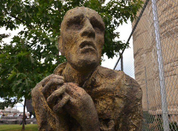 close up of one of the sculptures in Ireland Park. It is a man with his hands clenched in front of him and a worried look on his face.