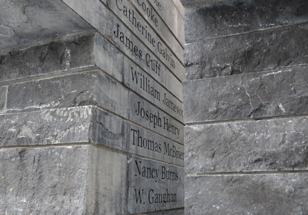 Names in black lettering carved into the side of limestone.