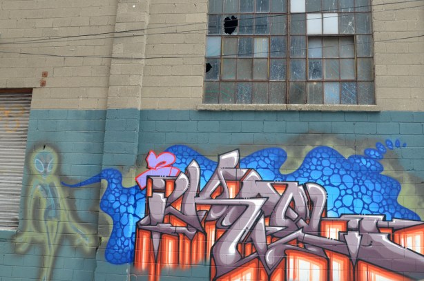 wispy space alien with a blue substance coming from its body and spreading into a purple and red tag