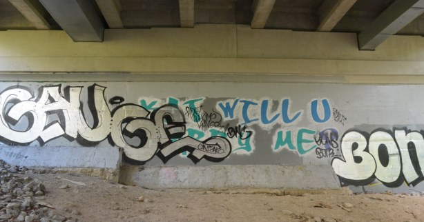 graffiti under a bridge - Kat Will you Marry Me?  was the original words on the wall.  It is partially obscured by a tag. 