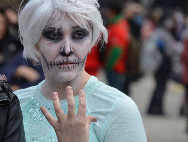 zombie from Toronto zombie walk - white hair, white face, vacant stare and holding her hand up in front of her chest