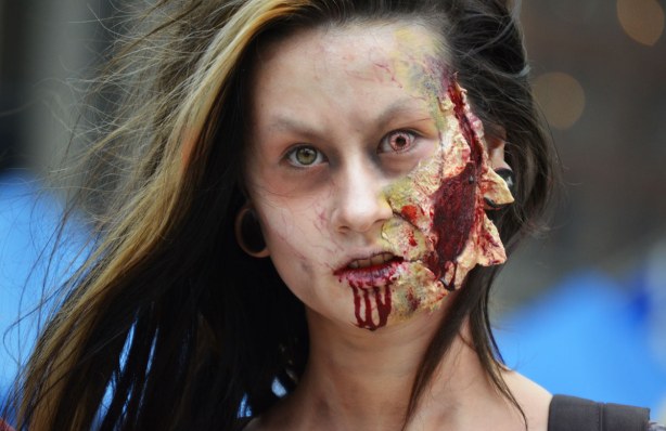 zombie from Toronto zombie walk, woman with large bloody gash on her cheek, blood running down her chin and eyes of different colours