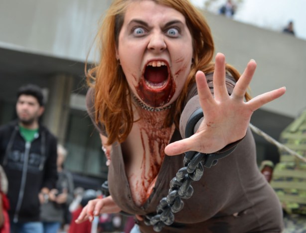 screaming woman zombie lunging for the camera but she is restrained by chains