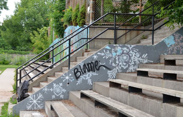 a black tag over a grey and white painting on the side of a set of stairs