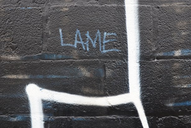 The word 'lame' is written on blue letters on a large black and white tag.