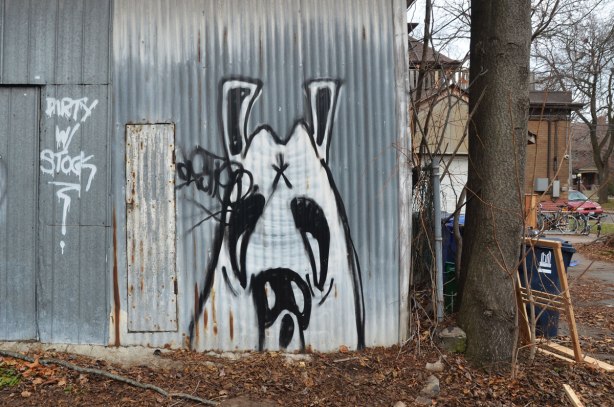 graffiti of a black and white dog's face on a metal garage