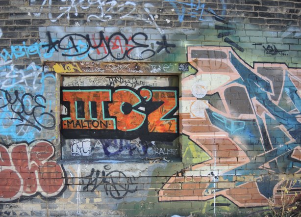 graffiti on a wall - a chaos of tags and colours on a brick wall 
