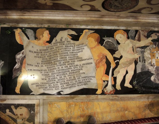 black, white, orange, gold tiles form memorials in the floor of St. Johns Co Cathedral in Valletta Malta. There are numberous angels, skulls and skeleton motifs that cover almost every inch of the cathedral floor.