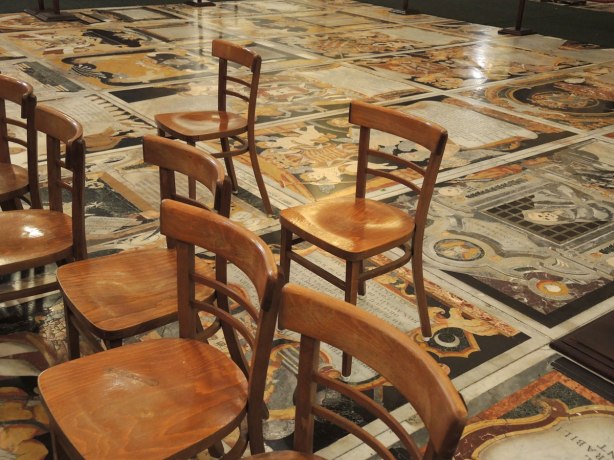 black, white, orange, gold tiles form memorials in the floor of St. Johns Co Cathedral in Valletta Malta. There are numerous angels, skulls and skeleton motifs that cover almost every inch of the cathedral floor.