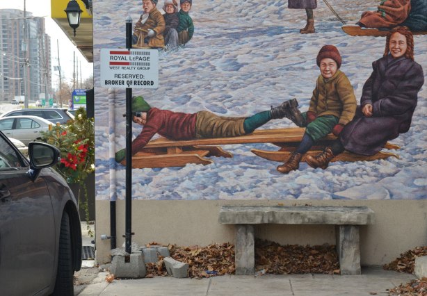 Close up of the bottom part of a mural whowing kids on old fashioned wooden sleds, or toboggans. 