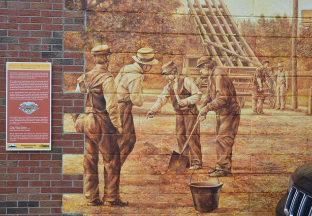 a mural showing a group of men in clothing from the 1930s shoveling in the dirt. 