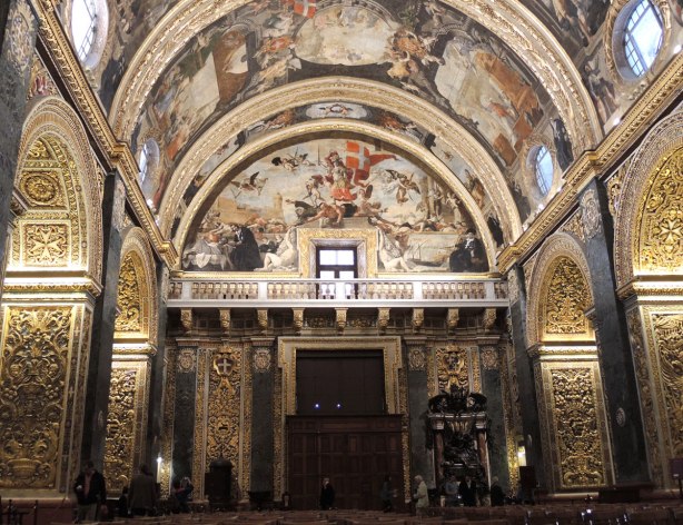 Looking down the nave of a cathedral to the back wall, all ceiling surfaces are painted.