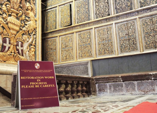 ornate panels on a wall of a cathedral that are being restored