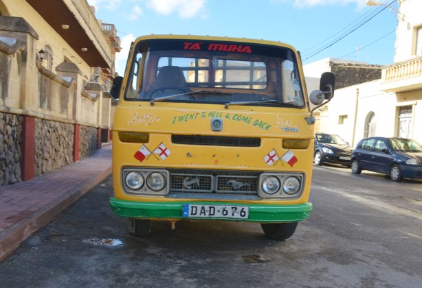 yellow van parked on the side of a street. The first three letters of the licence plate are D A D which spells dad. The words 'I went to hell and come back' are written across the front of the van.