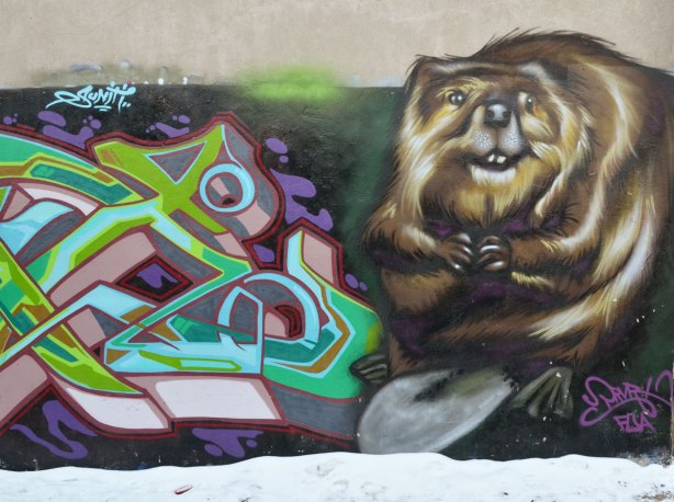 Lifelike painting of a beaver, but larger than life. Very realistic looking, sharp front teeth, little arms and big flat tail.