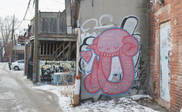 large pink creature street art, a small pink heart with the words 'lost doggy' is beside the creature