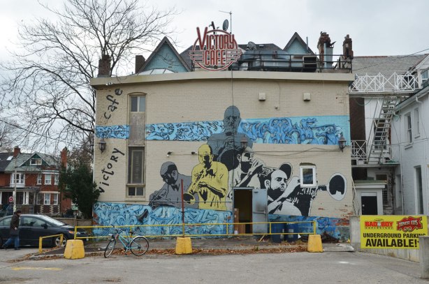 mural on a two storey light grey brick building showing musicians.